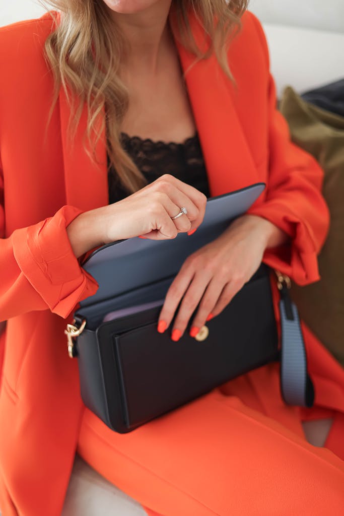 Woman in Red Suit Closing a Black Leather Purse